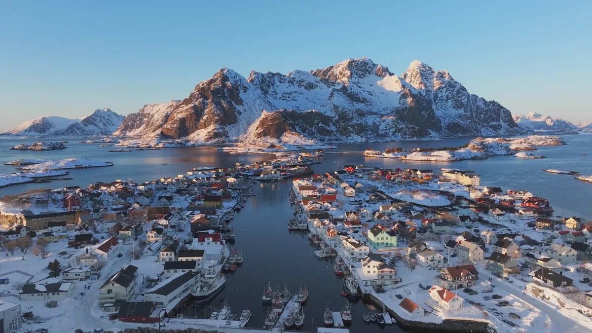 A snow-covered coastal village seen in aerial footage from a DCX camera drone.